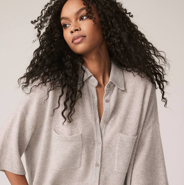 A beautiful woman of color wears a lightweight, oversized cashmere shirt for spring.
